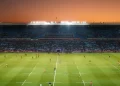 Exciting rugby game unfolding under stunning sunset in large stadium