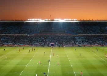 Exciting rugby game unfolding under stunning sunset in large stadium