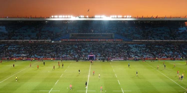 Exciting rugby game unfolding under stunning sunset in large stadium