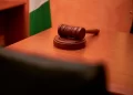A close-up of a gavel on a courtroom desk representing law and justice