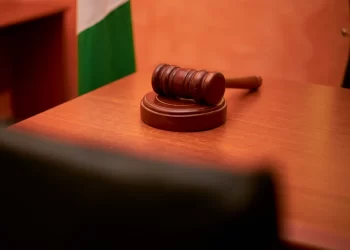 A close-up of a gavel on a courtroom desk representing law and justice