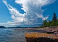 Rocky Lake Superior shoreline in northern Ontario with pine forest under a summer sky