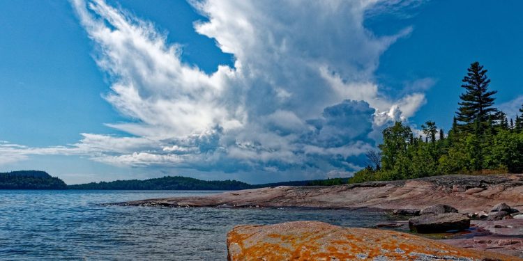 Rocky Lake Superior shoreline in northern Ontario with pine forest under a summer sky